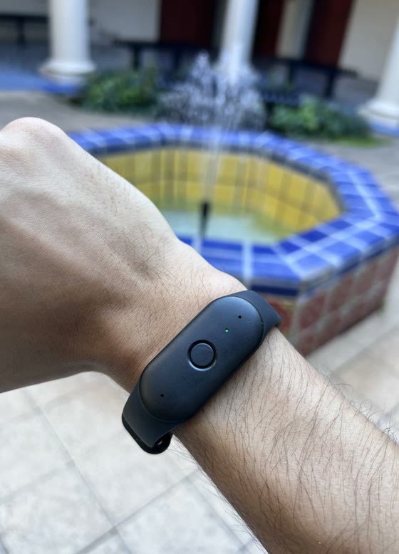 A Bee wearable on a student's wrist in a campus courtyard